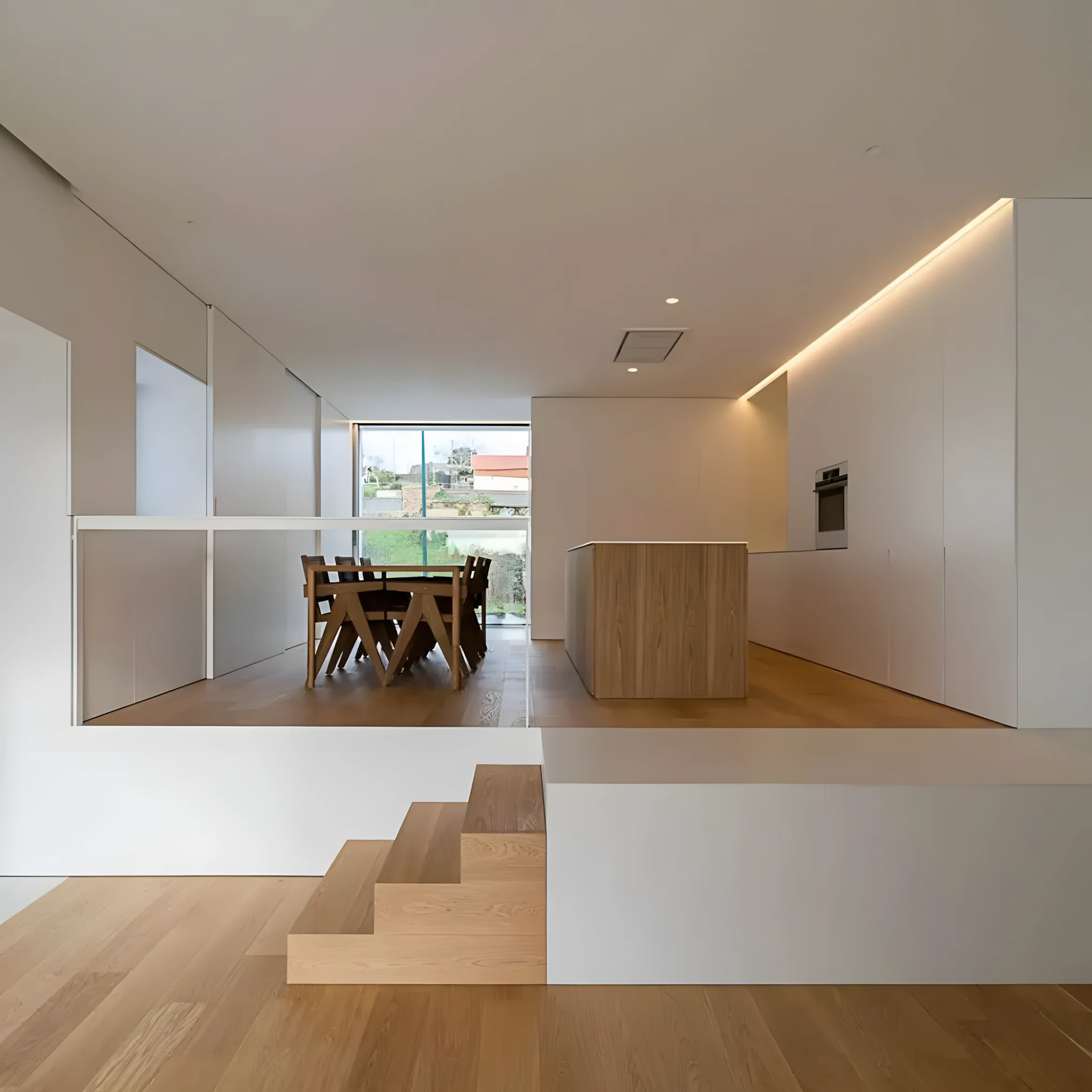 Zona de estar/comedor/cocina en doble altura o espacio abierto, con mobiliario integrado y luz natural.